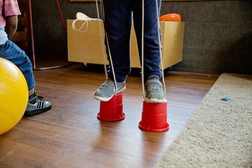 Why choose ORNS? - Child walking on toy stilts in the indoor gym